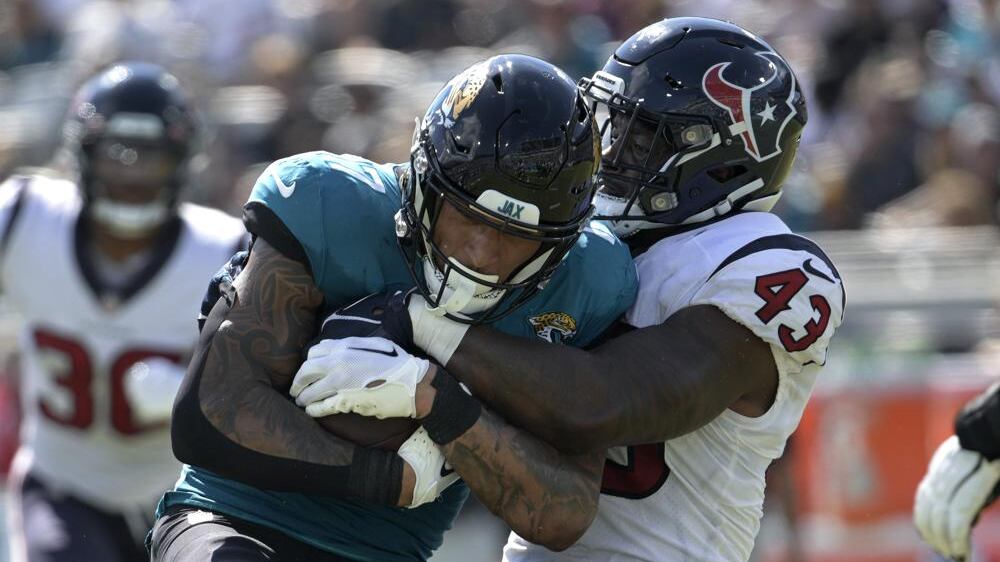 Jacksonville Jaguars tight end Evan Engram (17) is tackled by Houston Texans linebacker Neville Hewitt (43) during the second half of an NFL football game in Jacksonville, Fla., Sunday, Oct. 9, 2022. (AP Photo/Phelan M. Ebenhack)